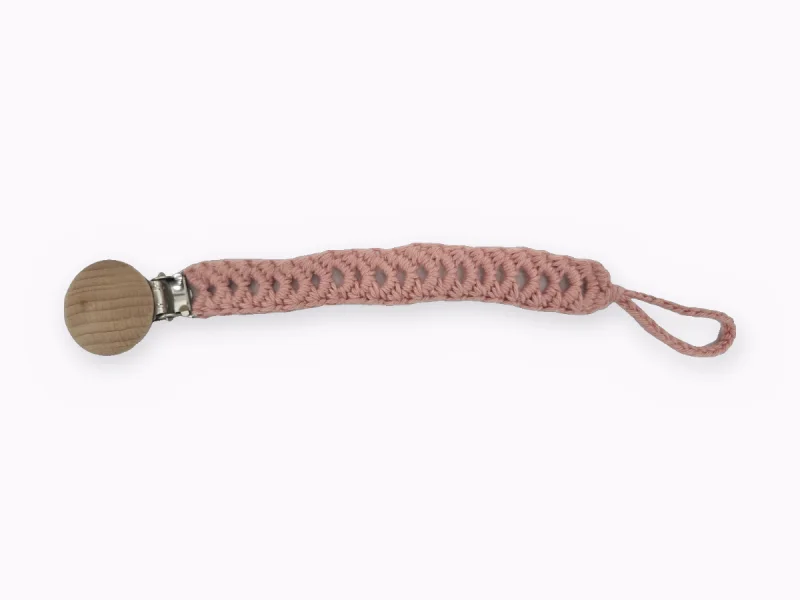Dusty pink crocheted pacifier clip with a round wooden clasp